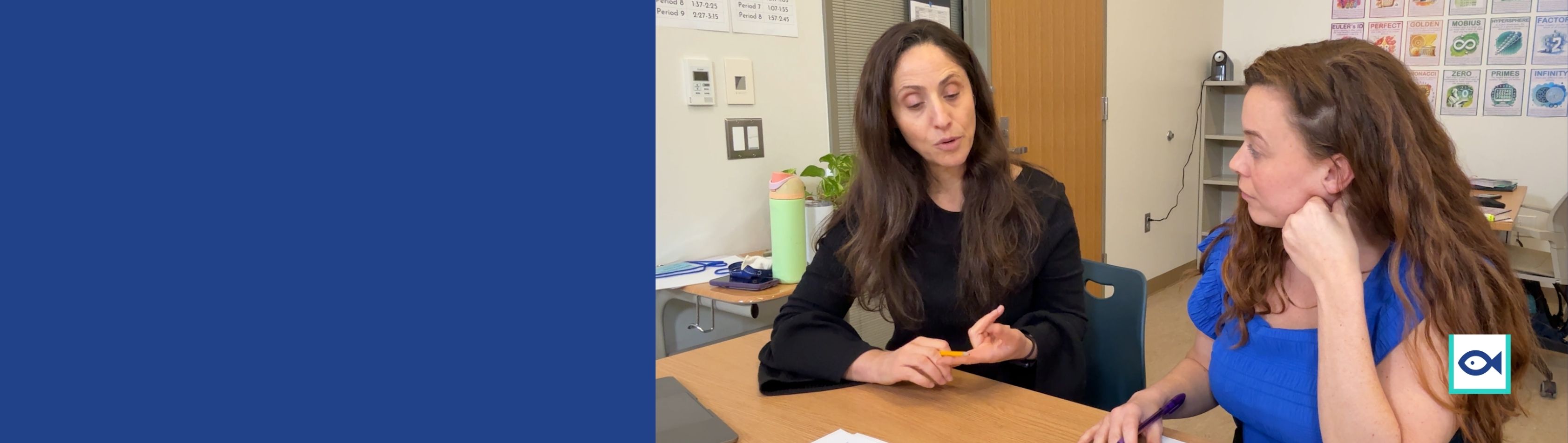 two women sitting at classroom desks talking