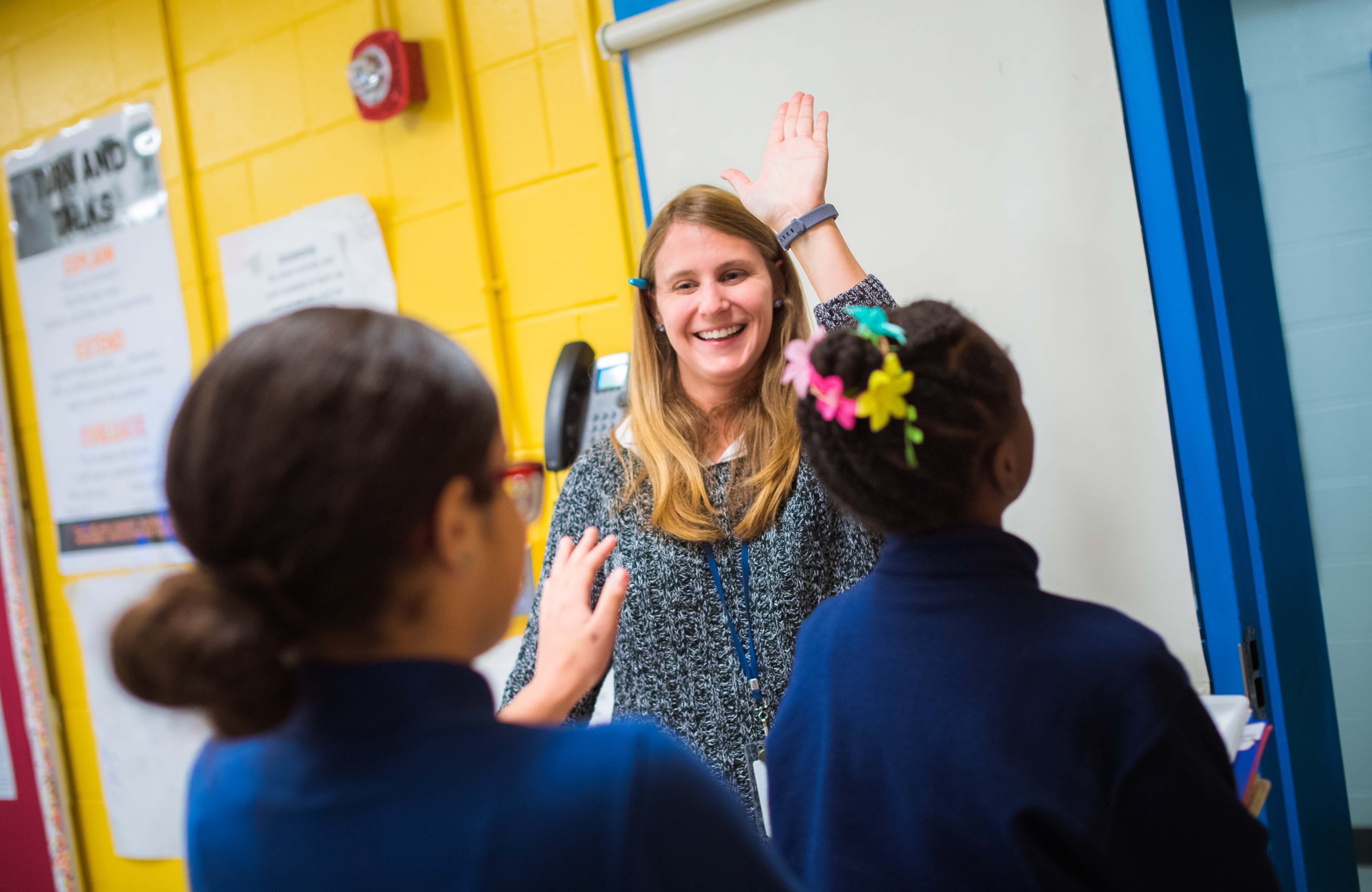 Teacher high-fiving students