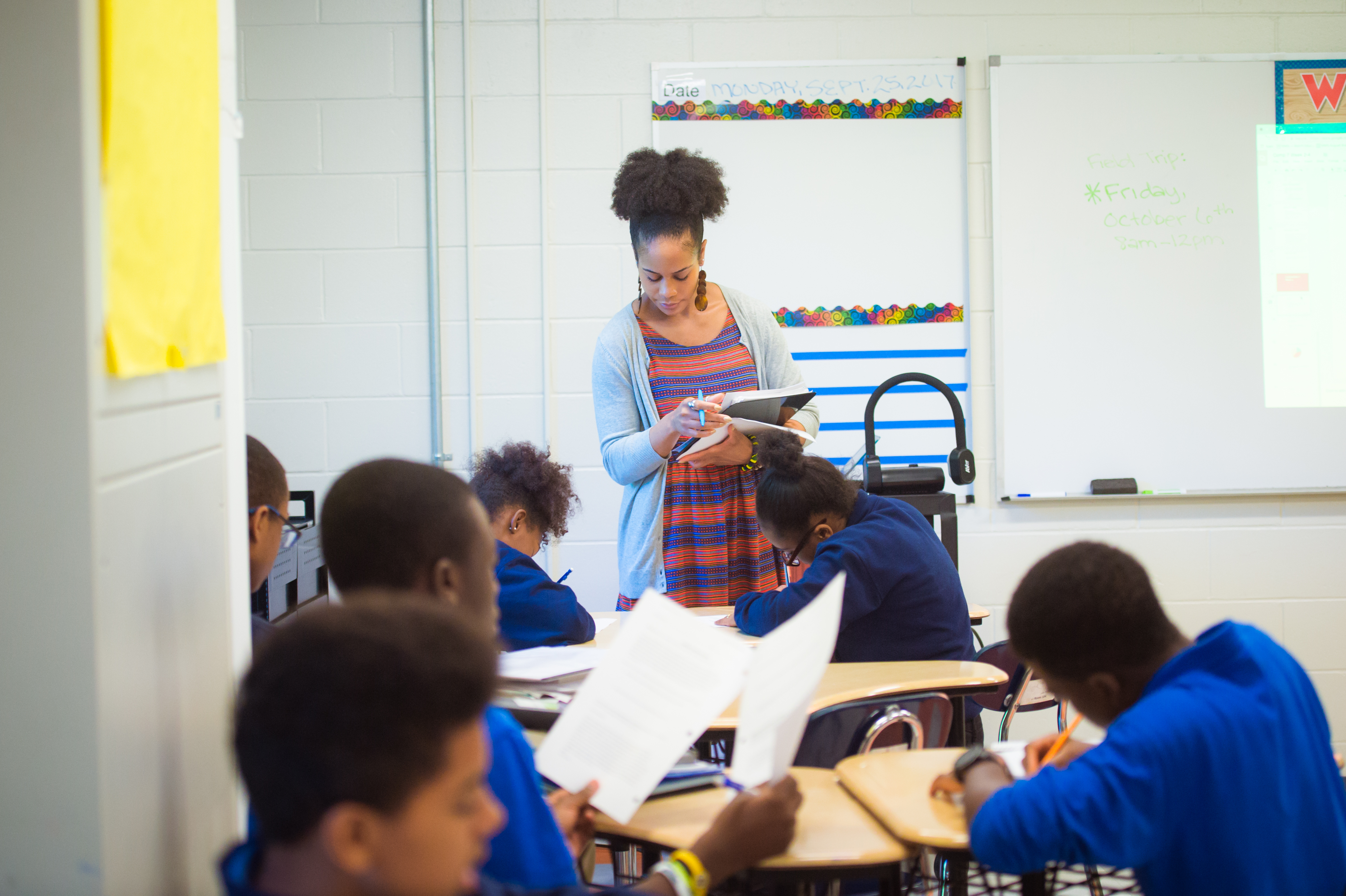 Teacher helping students at their desks